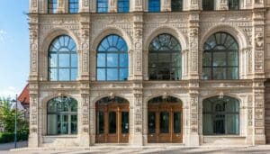 The image depicts a beautifully renovated historic building in the heart of a Czech city showcasing elegant architecture that blends seamlessly with modern elements