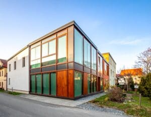 Moderný dom s ultra tenkým vákuovým zasklením vedľa historických budov v Bratislave, kontrast medzi moderným dizajnom a tradíciou